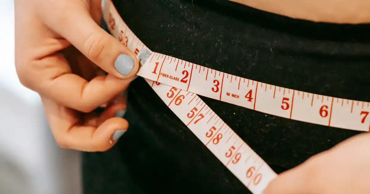 Woman measuring waist to see if losing weight. Would Aplilean work for weight loss? Used for an alpilean review.